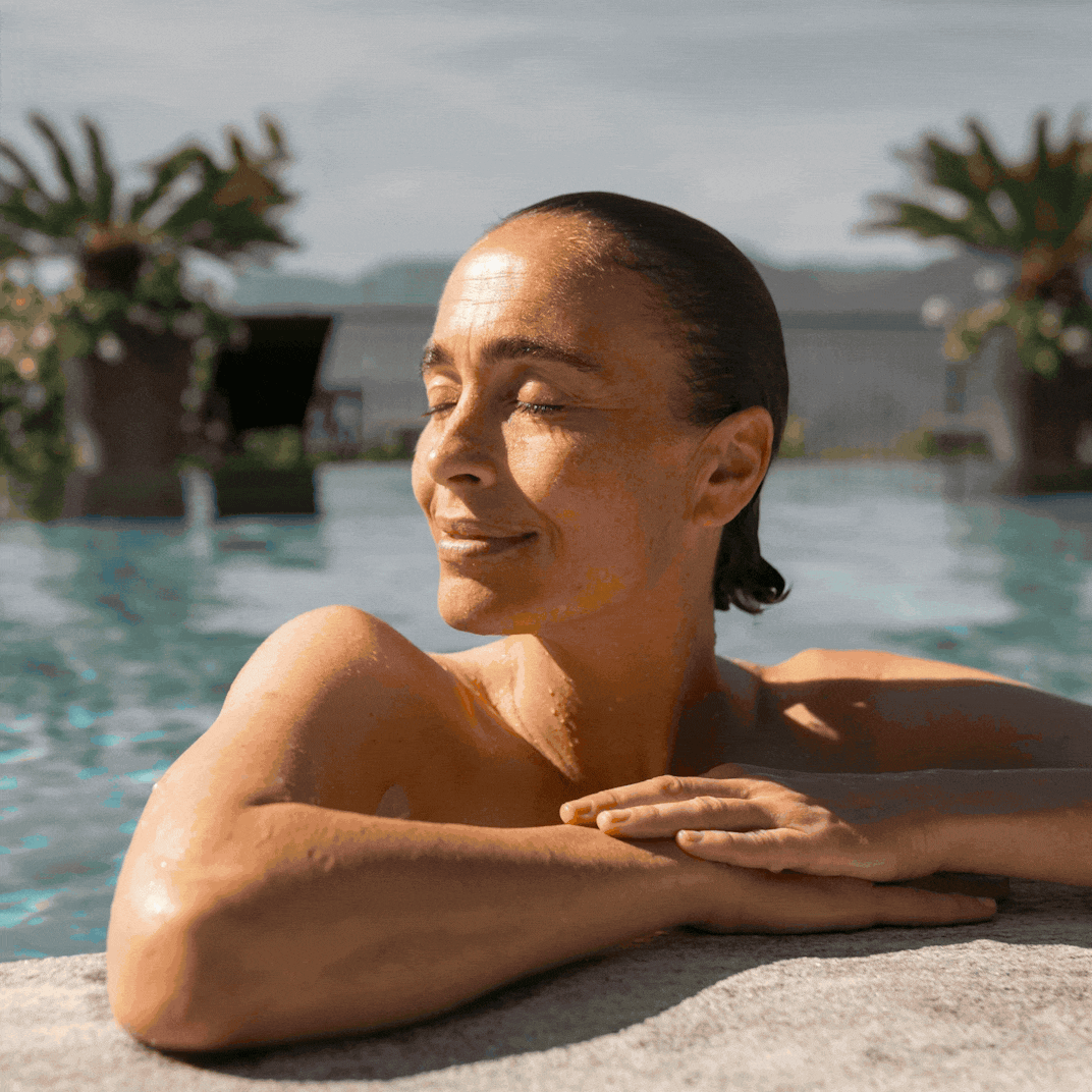 Eine Frau entspannt am Pool und genießt die Sonne im Sommer.